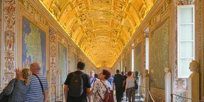 Turistas caminhando pela Galeria de Mapas nos Museus Vaticanos