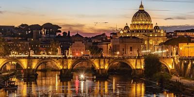 Ponte Sant'Angelo illuminato e cupola della Basilica di San Pietro riflesse nel fiume Tevere