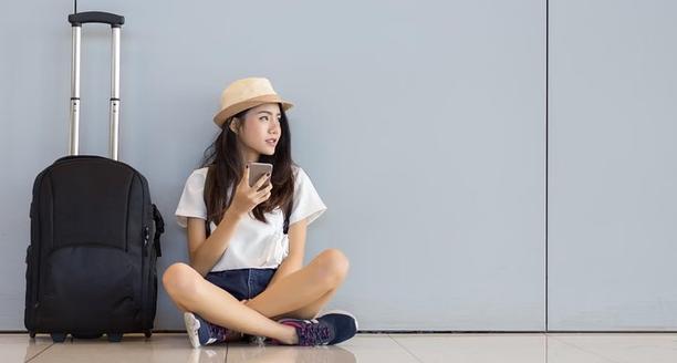 Femme assise à côté de sa valise