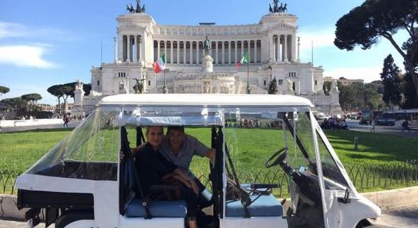Pareja dentro de un carrito de golf frente al Altar de la Patria