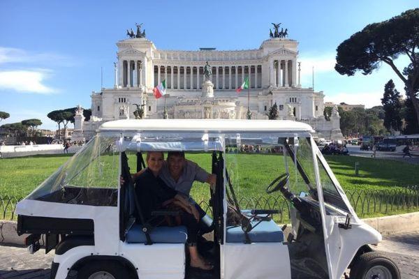 Pareja dentro de un carrito de golf frente al Altar de la Patria