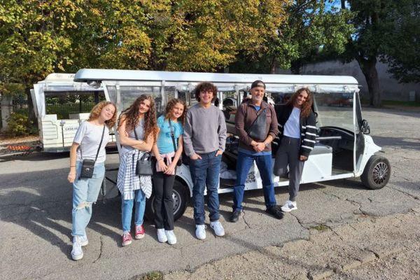 Personas de pie frente al carrito de golf