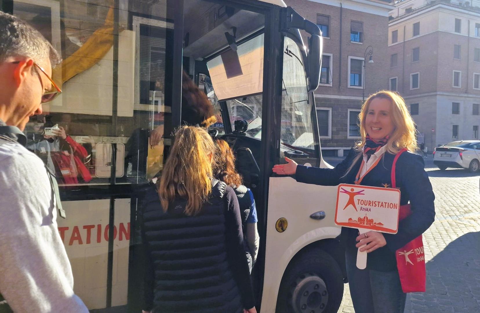 Touristation guide leading visitors towards the bus