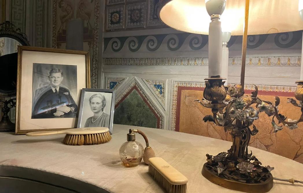 Penteadeira vintage com produtos de beleza essenciais e fotografias dentro do Palazzo Doria Pamphilj