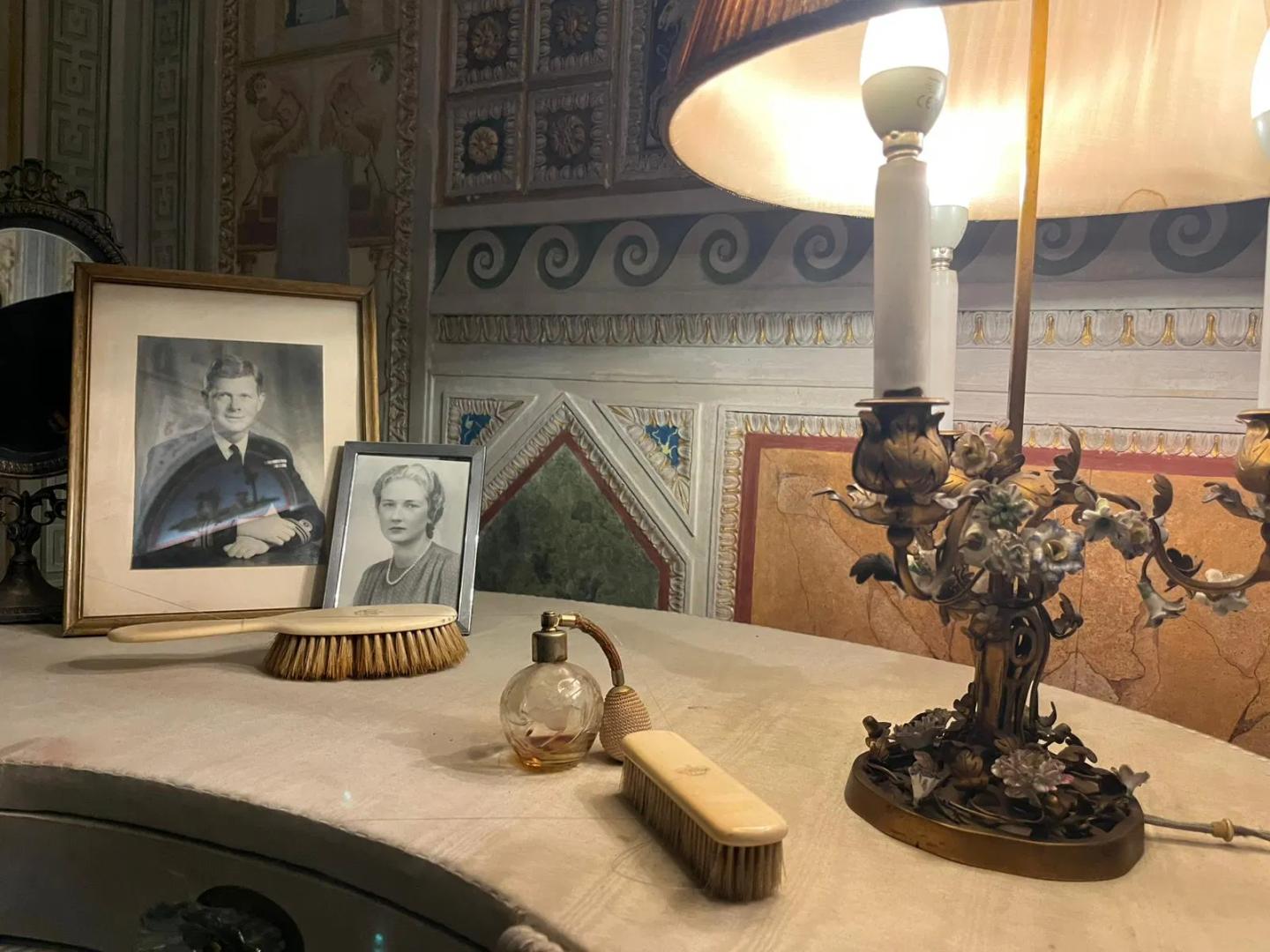 Tocador vintage con productos de belleza esenciales y fotografías dentro del Palazzo Doria Pamphilj