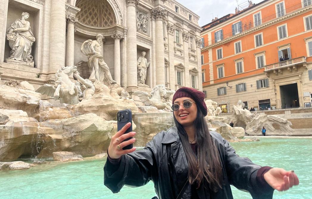 Mulher tirando uma foto em frente à Fontana de Trevi