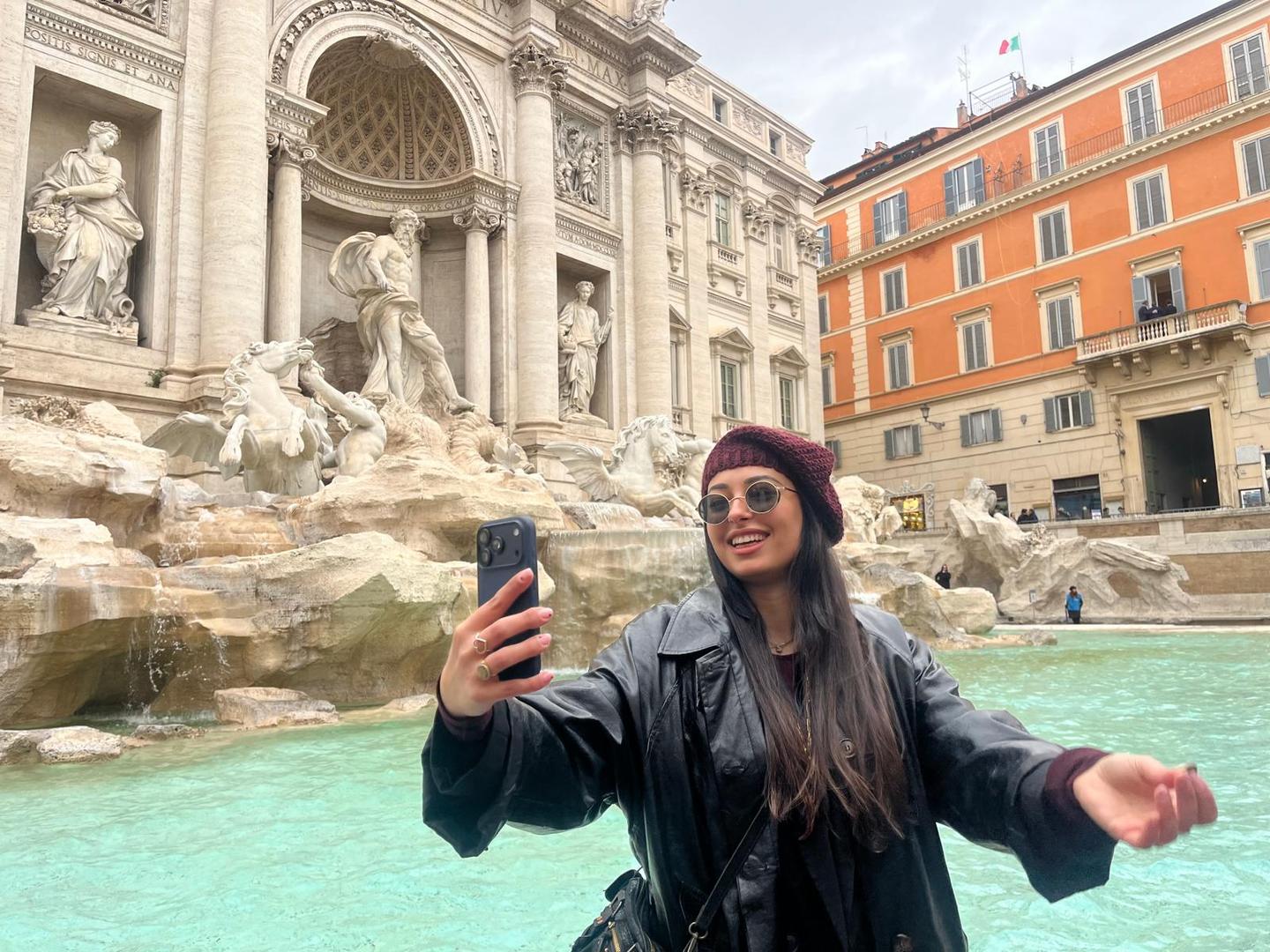 Frau macht ein Foto vor dem Trevi-Brunnen