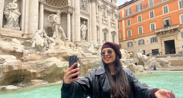 Femme prenant une photo devant la fontaine de Trevi